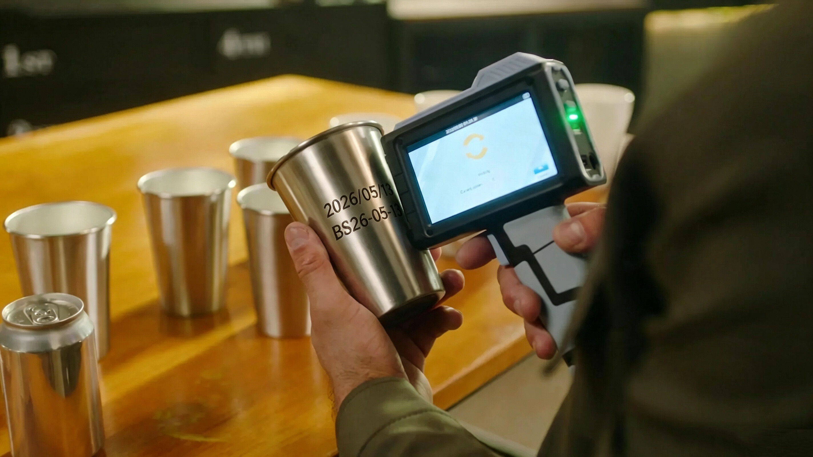 Operator_using_a_handheld_inkjet_printer_to_mark_expiration_date_and_lot_code_on_metal_beverage_cans